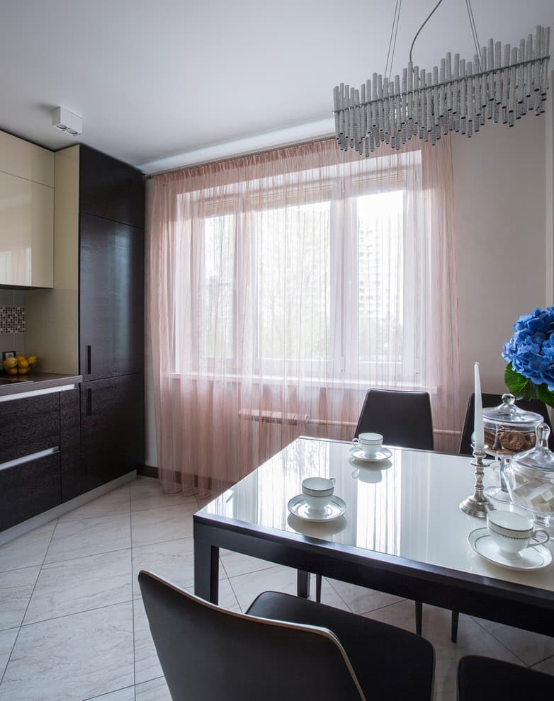 Pink tulle on the kitchen window in a studio apartment