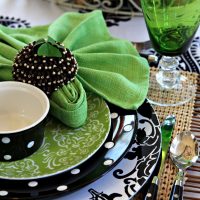 Green napkins on plates with black ornament