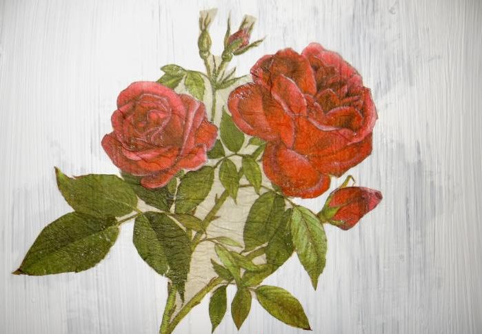 Drawing roses on the painted surface of an old cabinet